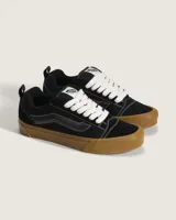 Championes Vans modelo Knu Skool, de estética inspirada en los años 90 con silueta voluminosa. Confeccionados en gamuza negra, presentan lengüeta y cuello acolchados, Sidestripe en diseño 3D y suela de goma color caramelo con patrón waffle.