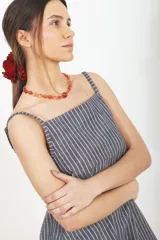 Vestido corto de lino a rayas, con silueta levemente evasé y calce relajado. Presenta escote recto y breteles finos con diseño de rayas verticales.