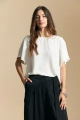 Top de color azul, con escote redondo a la base y mangas cortas amplias con caída fluida. Presenta una silueta relajada y un diseño minimalista.