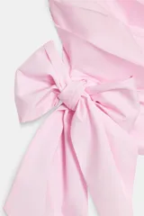 Top halter entallado de popelina color rosado, con diseño de pliegues en diagonal y lazo ajustable en el bajo. Cuenta con cierre lateral con cremallera oculta en la costura.