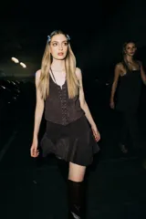 Minifalda de cuero color marrón oscuro, con fajón en la cintura y volados en el ruedo.