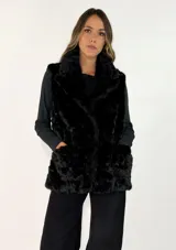 Chaleco de piel sintética en color negro, con cuello alto y diseño sin mangas. Presenta una textura suave y voluminosa, ideal para climas fríos.