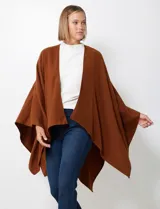 Ruana de tejido soft, color marrón óxido, de corte amplio y sin cierres, con cuello redondo.