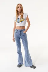 Top blanco con cuello redondo y sisas amplias. Estampado frontal con forma de labios en colores amarillo, azul y negro.