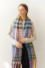 Bufanda larga con estampado a cuadros en tonos celeste, azul, rojo, verde y blanco. Incluye flecos multicolores en los extremos.
