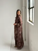 Vestido largo marrón de lino con estampado floral, cuello redondo holgado y mangas tres cuartos.