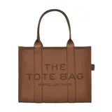 Bolso tipo tote de gran tamaño, confeccionado en cuero negro con textura granulada. Presenta el logo de la marca estampado en el frente con la inscripción The Tote Bag Marc Jacobs. Cuenta con asas superiores resistentes y un diseño espacioso.