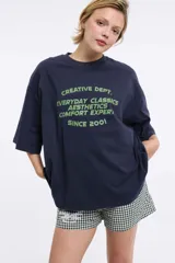 Remera blanca de corte boxy, cuello redondo a la base y mangas cortas. Presenta un pequeño estampado localizado en el centro del pecho que simula un ají en tono rojizo.