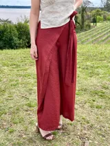 Pantalón terracota con diseño de cruce frontal y lazo para ajustar en la cintura, confeccionado en tela efecto lino con textura, de pernera ancha y corte suelto.