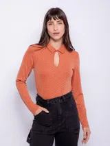 Top color beige de manga larga con cuello camisero y abertura ovalada en el escote. Su tela es flexible y consta de finas fibras metálicas.