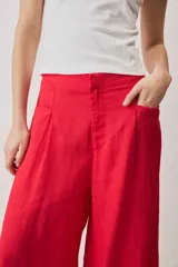Pantalón rojo de corte ancho, estilo palazzo, tiro alto y bolsillos laterales.