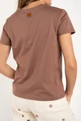 Remera de algodón peinado color blanco, con escote en V y detalles de lurex dorado en el borde del escote. De manga corta y corte ajustado.