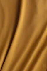 Pantalón holgado de punto suave color mostaza con elástico oculto en la cintura y perneras amplias.