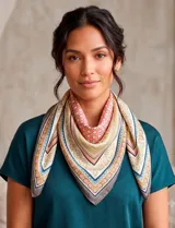 Pañuelo cuadrado de satén con estampado geométrico y floral en tonos turquesa, naranja, azul y beige.