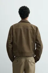 Cazadora cropped fit de efecto piel en color verde militar, con cuello solapa, manga larga con puño abotonado, bolsillos frontales de plastrón con solapa y cierre de botonadura.