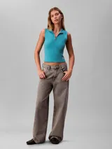 Musculosa Calvin Klein de corte slim confeccionada en tejido de punto de canalé fino. Presenta cuello perkins con cierre frontal parcial y etiqueta tejida con el logo monograma en el bajo.