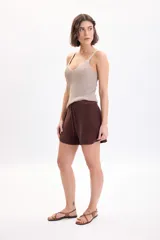 Short de tejido de punto marrón con hilo lurex, tiro medio y cintura elástica con cordón ajustable.