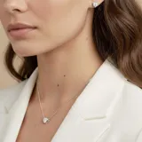 Set de joyería compuesto por collar con dije de corazón y aros tipo caravanas, ambos realizados en plata 925 con incrustaciones de circonias brillantes.