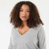 Remera de punto color gris, con cuello en V y mangas largas.