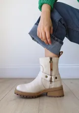 Botas cortas color crudo de cuero, con cierre lateral, pulsera desmontable y suela marrón.