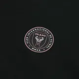 Canguro negro con capucha y cordones rosas, bolsillo tipo canguro y puños acanalados. Logo del Inter de Miami en el pecho y logo de la MLS en la manga.