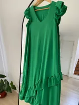 Vestido largo de simil lino con volados en el ruedo y mangas cortas con volados.
