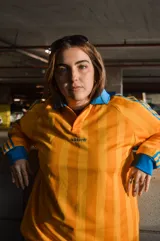 Camiseta de manga larga Adidas Originals, de corte holgado y color amarillo con rayas verticales sutiles en tono más oscuro y detalles en azul en cuello polo, puños y las clásicas franjas en las mangas. Cuenta con el logo bordado en el pecho.