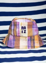 Gorro tipo bucket con estampado a cuadros en tonos lila, amarillo y naranja.