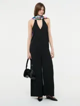 Mono largo negro con escote halter y espalda descubierta.