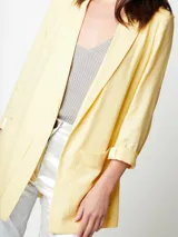 Blazer oversized lila de corte recto, largo a la cadera, con hombreras finas forradas, costuras internas con sesgo combinado y maxi bolsillos delanteros. Incluye lazo de algodón con detalle a tono.