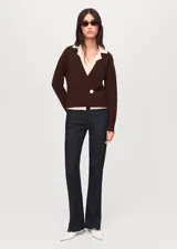 Cardigan de punto marrón oscuro con diseño cruzado, escote en V con solapas en tono crudo y cierre de un botón lateral en contraste.