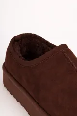 Zueco tipo mule de gamuza negra con interior forrado en piel sintética y plataforma alta de goma.