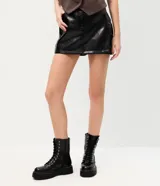 Short pollera de poliuretano color marrón, con diseño que imita el cuero, cintura con trabillas, bolsillos delanteros y bolsillo lateral estilo cargo.