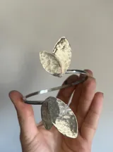 Brazalete dorado para el brazo, con forma de hojas texturizadas.