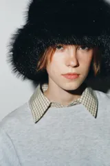 Gorro tipo bucket confeccionado en pelo sintético negro, con forro interior a tono.