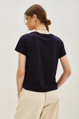 Remera de algodón color azul marino con cuello redondo y mangas cortas. Presenta un estampado de corazones formados por pequeñas aplicaciones brillantes distribuidas por toda la prenda.