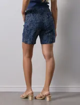 Short de gabardina elastizada con estampado floral en tonos azules, rosas y violetas. Pretina ancha elastizada y bolsillos delanteros.