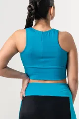 Top deportivo de color azul francia, con escote redondo y breteles anchos. Presenta un diseño de faja ancha en la parte inferior para mayor sujeción y ajuste al cuerpo.