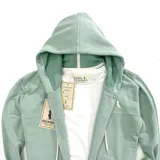 Campera con capucha verde agua, con cierre frontal y bolsillos tipo canguro.