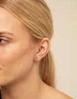 Aro piercing dorado con forma de cruz.