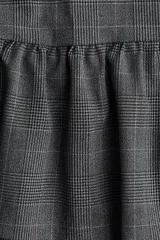 Pollera mini de corte ajustado con cintura clásica y cierre lateral oculto. Presenta un diseño con costura fruncida en el bajo que genera una silueta acampanada con vuelo.