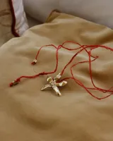 Collar tipo gargantilla con dije de flor metálica de acabado brillante, suspendido de un cordón doble de seda natural teñido a mano en color rojo.