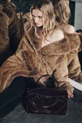 Bolso marrón de cuero con doble asa de mano. Tiene bolsillos exteriores, uno con cierre mediante imán, y doble compartimento interior con cierre mediante botón imantado. Incluye bolsillos interiores con cremallera.