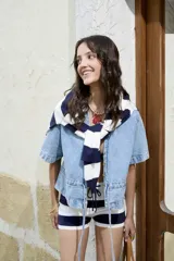 Blusa de jean de manga corta, corte holgado, con cuello en V, cierre frontal con botones y detalles de frunces.