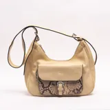 Bandolera color amarillo claro de diseño hobo, con bolsillo frontal con solapa e inserto en símil piel de serpiente con hebilla metálica. Cuenta con cierre superior y correa ajustable.