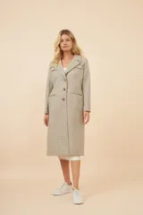 Tapado largo de corte recto confeccionado en lana fina sin teñir. Presenta cuello solapa, cierre frontal con botones, bolsillos laterales con tapa y detalles aplicados en la parte delantera. Incluye forro interior y tajo en la espalda.