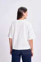 Remera blanca de manga corta con estampa de una cafetería en color rojo y texto "New York Albany, 1990".