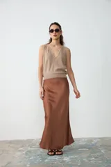 Chaleco tejido de punto sin mangas, color beige, con escote en V profundo y dobladillo acanalado.