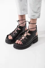 Sandalias de cuero color marrón con textura de cocodrilo, plataforma con suela track y tiras finas que se atan al tobillo.