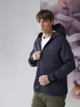 Campera verde oscuro con capucha, cierre frontal y bolsillos laterales.